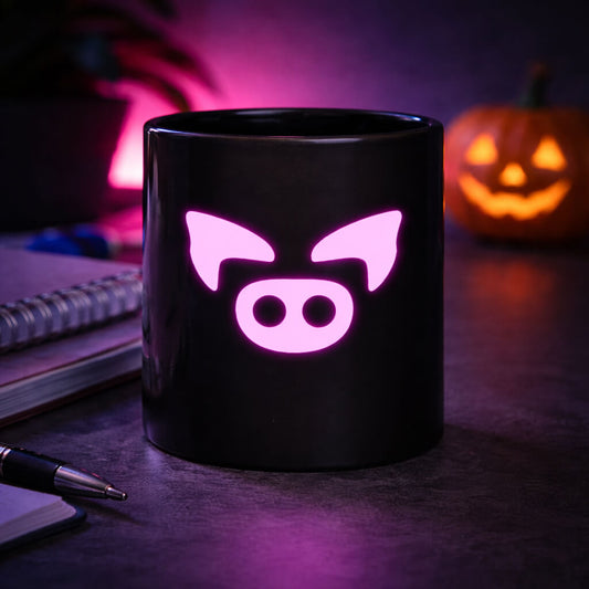 Black mug with the Slapped Ham Icon on a dark surface with Halloween decorations.