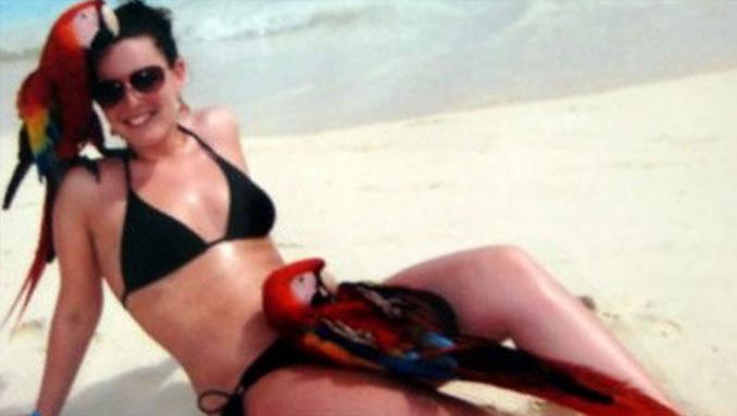 A girl in a bikini at the beach with two macaws - 10 photos you won't believe weren't photoshopped.