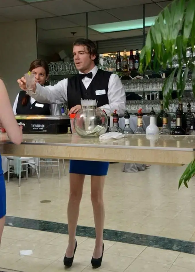 A photo of a male bartender with female legs in high heels - 10 Amazing Photos Taken At Just The Right Time