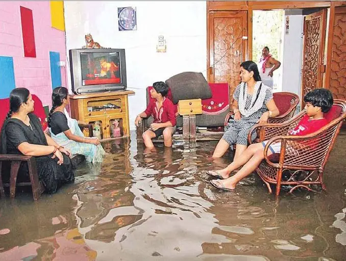 Indian family watching T.V. during a flood - 20 WTF Photos You Just Have To See