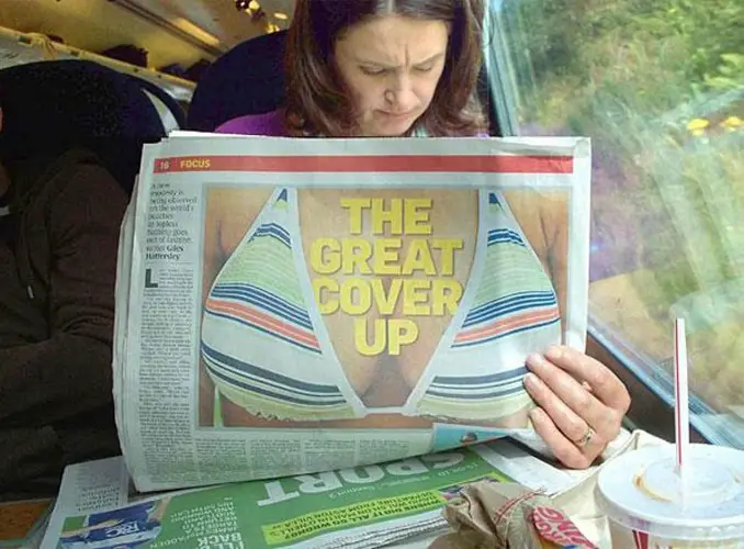 A lady holding a newspaper with a picture of a bikini on it - 20 WTF Photos You Just Have To See