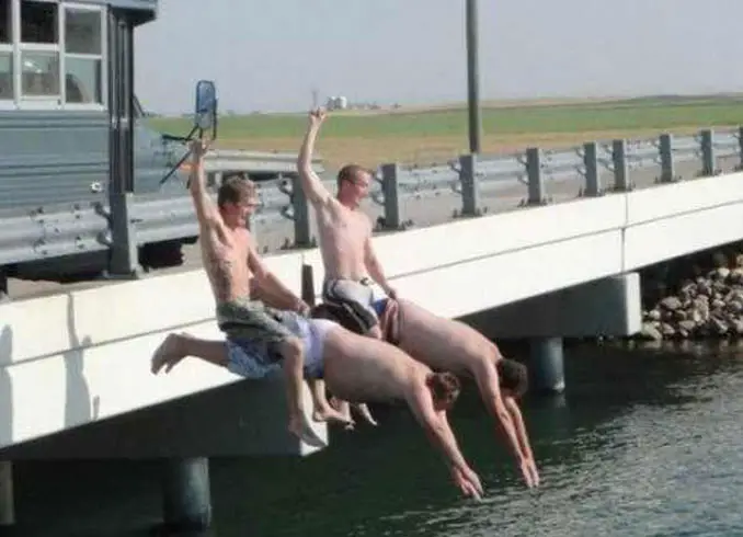 Two men riding two other men while diving into a river - 20 WTF Photos You Just Have To See