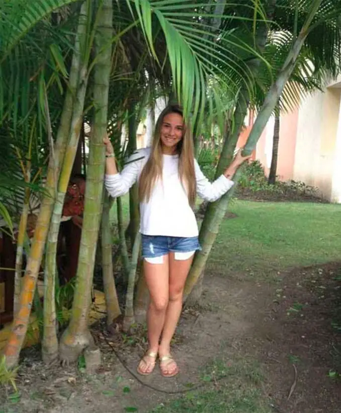 Two scary people photobomb a young girl standing near a palm tree - 10 Most Chilling Photobombs Ever Caught On Camera