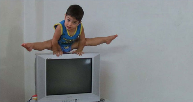 Arat Hosseini doing the splits on a T.V.