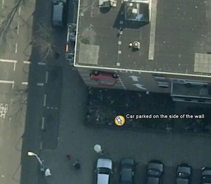 A car parked on the side of a building seen on Google Earth.