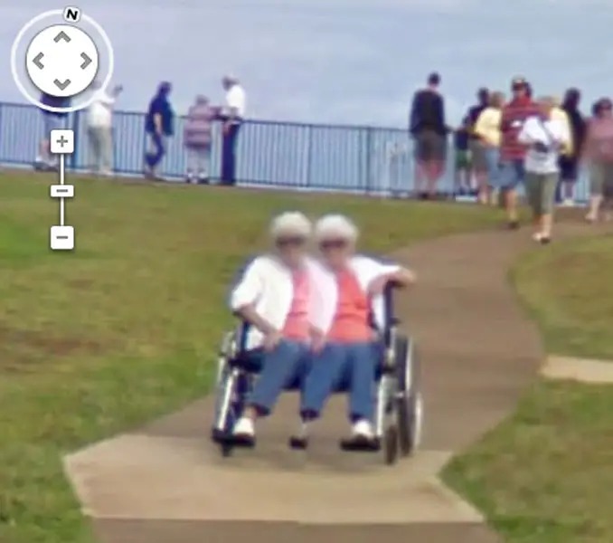 An old lady with two heads and three legs seen on Google Street View.