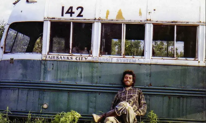 Chris McCandless sitting next to a bus - These Real Photos Have Very Disturbing Backstories