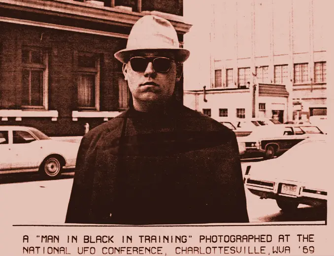 Photograph of a man in black taken by Allen Greenfield outside the 1969 National UFO Conference in Charlottesville, Virginia - Real Men in Black Sightings Caught on Camera