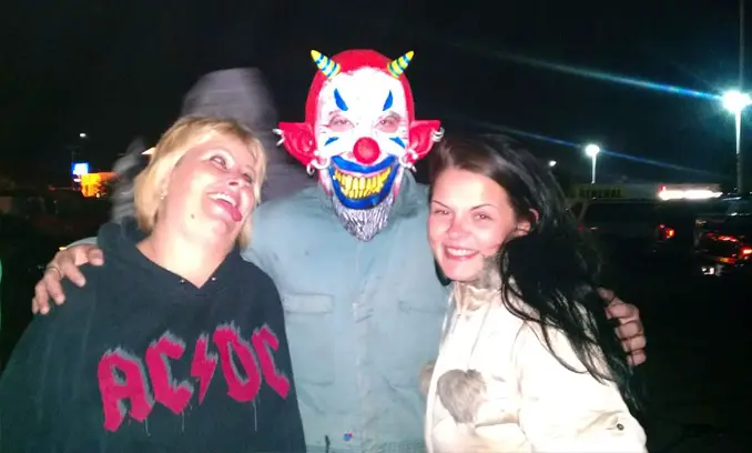 Group photo taken at haunted house attraction, weird ghost in the background.