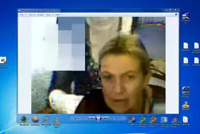 Screen capture of a father on Skype to his son. There's a strange unaccounted for person in the background. 